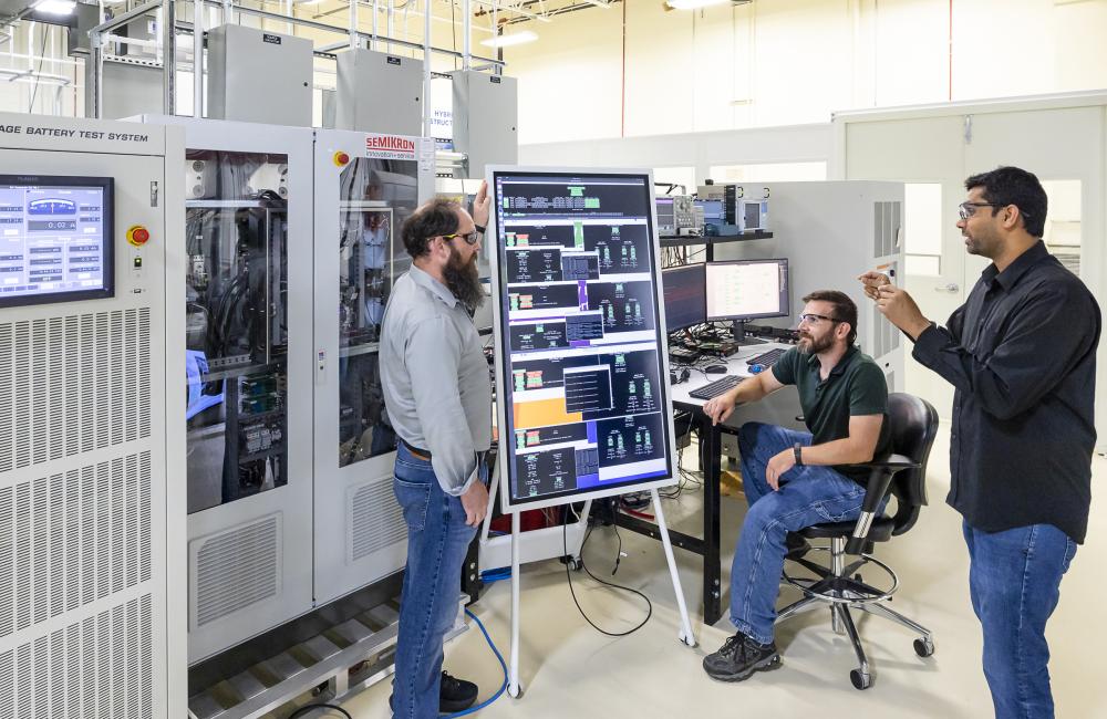 From left, Michael Starke, Steven Campbell and Madhu Chinthavali of ORNL discuss the configuration of the power electronics hub demonstrated with hardware in the low-voltage lab at GRID-C. Credit: Carlos Jones/ORNL, U.S. Dept. of Energy