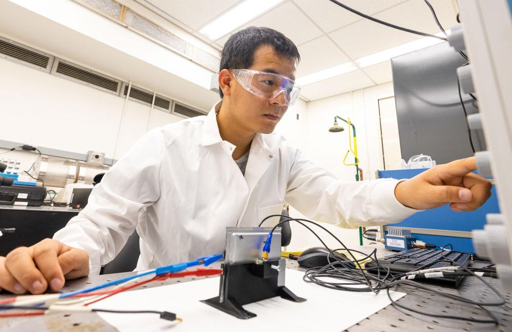 Researcher Sun Hongbin examines material changes to a battery made in the DOE’s Battery Manufacturing Facility using an ultrasound sensor. Credit: Carlos Jones/ORNL, U.S. Dept. of Energy