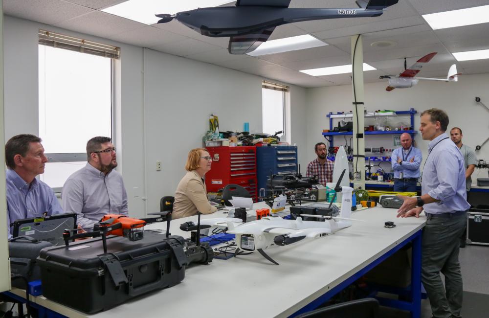 People around a table with drones