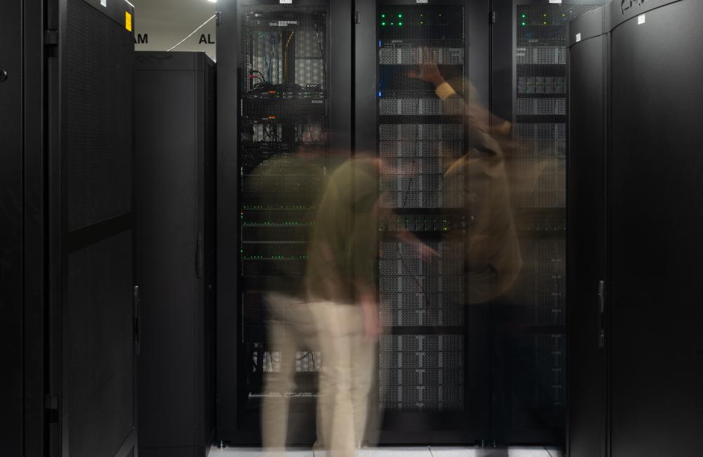 Action shot of two men in front of Cumulus computing cluster