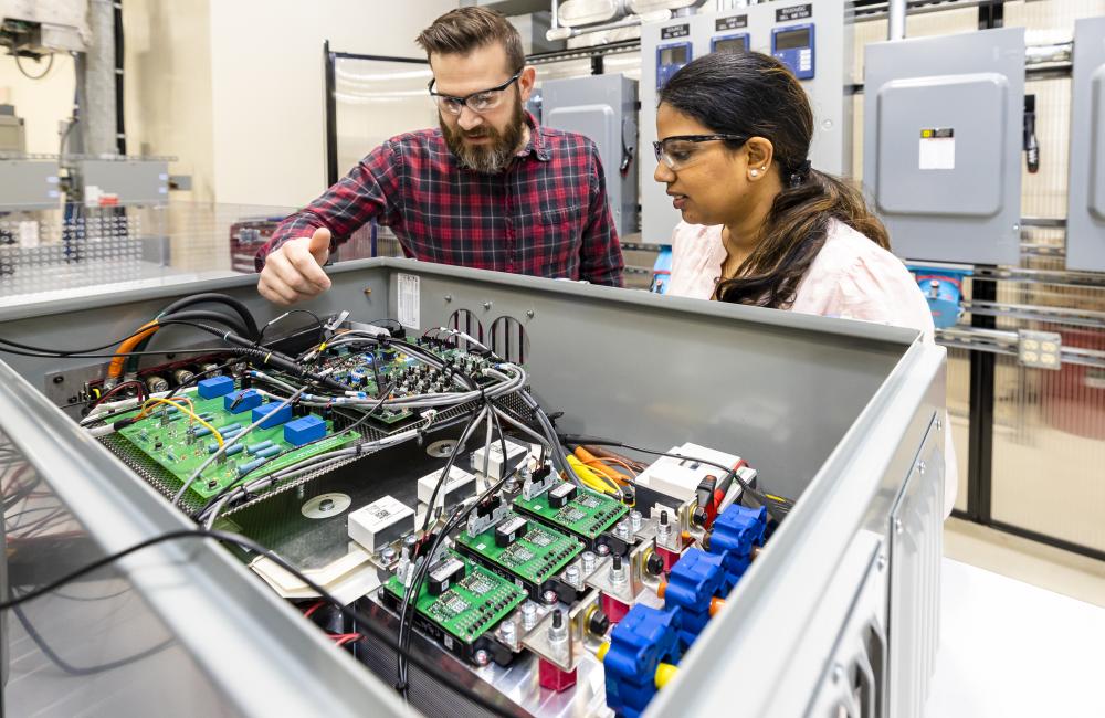 Steven Campbell and Radha Krishna-Moorthy discuss part of the power electronics that make up the Smart Universal Power Electronics Regulator technology developed at ORNL. Credit: Carlos Jones/ORNL, U.S. Dept. of Energy