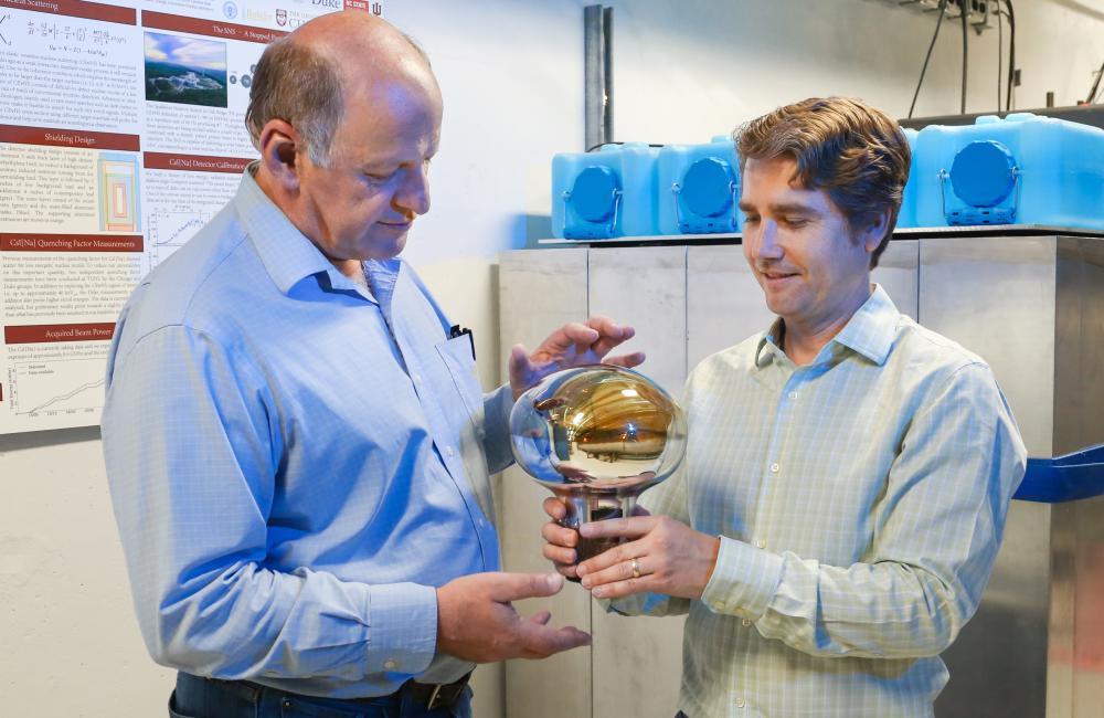 ORNL’s Jason Newby and Yuri Efremenko hold a photosensor used for particle detection in Neutrino Alley. Credit: Genevieve Martin/ORNL, U.S. Dept. of Energy
