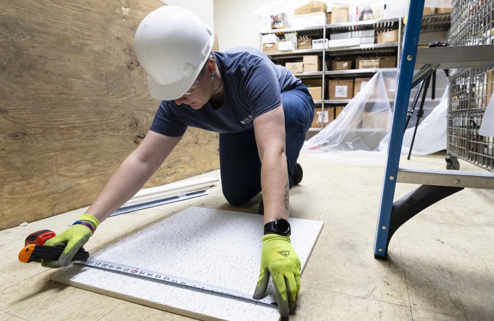 volunteer measuring ceiling tiles at the Love Kitchen