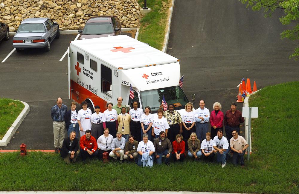 Group of disaster relief volunteers in front of an emergency response vehicle