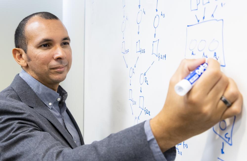 Person in a suit writing on a whiteboard