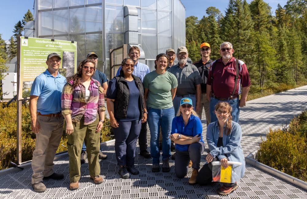 Front row: Victoria DiStefano and Dr. Asmeret Asefaw Berhe of DOE toured the SPRUCE experiment with Natalie Griffiths, Melanie Mayes, and Verity Salmon; back row: Dave Weston, Stephen Sebestyen (US Forest Service), Jonathan Stelling, Mark Guilliams, John Latimer (ORNL contractor), Kyle Pearson and Paul Hanson. Credit: Genevieve Martin/ORNL, U.S. Dept. of Energy