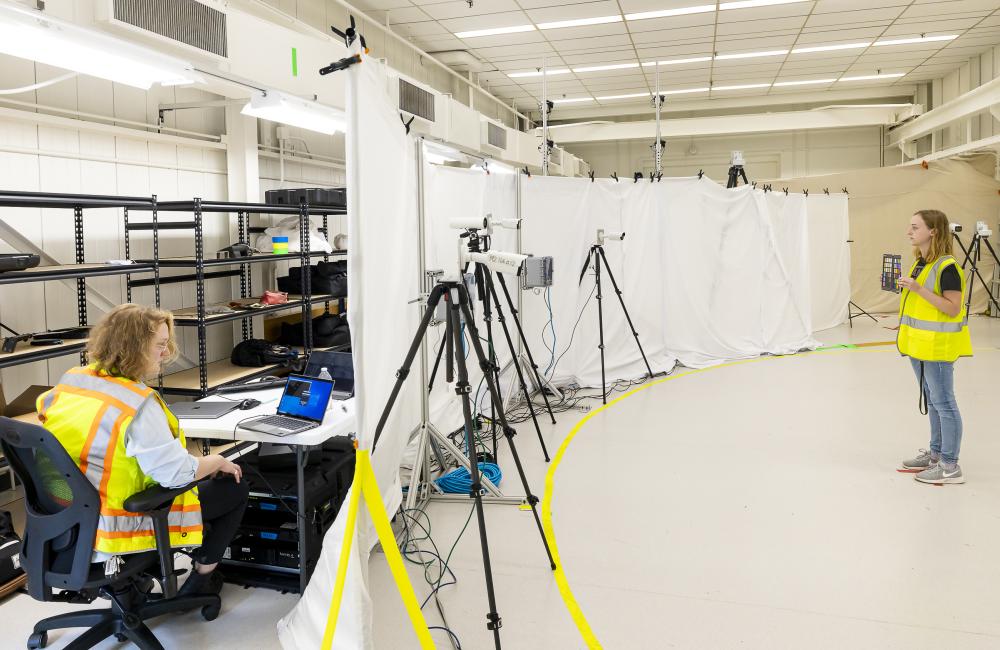 A woman stands in front of an array of cameras