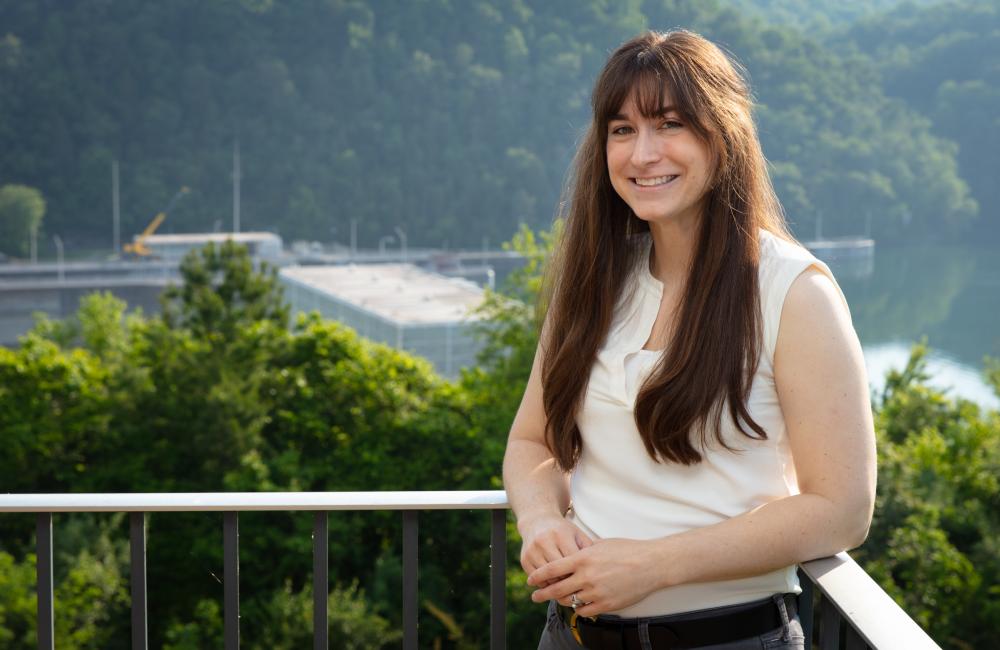 ORNL researcher Carly Hansen poses next to Melton Hill Dam