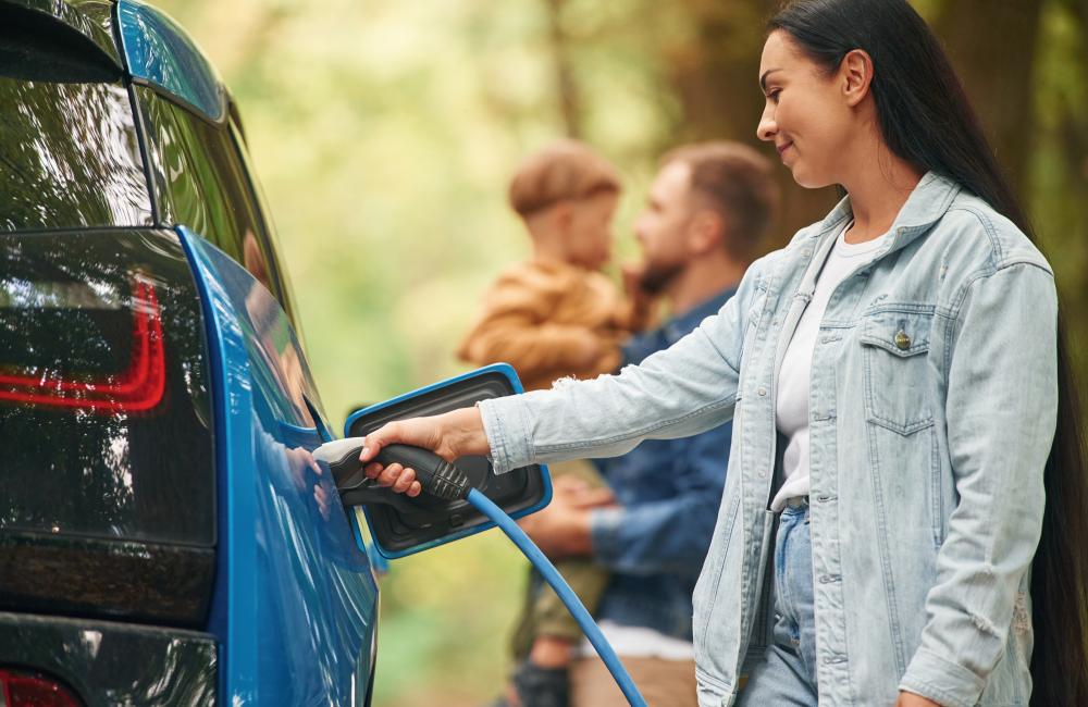 Woman charging electric vehicle