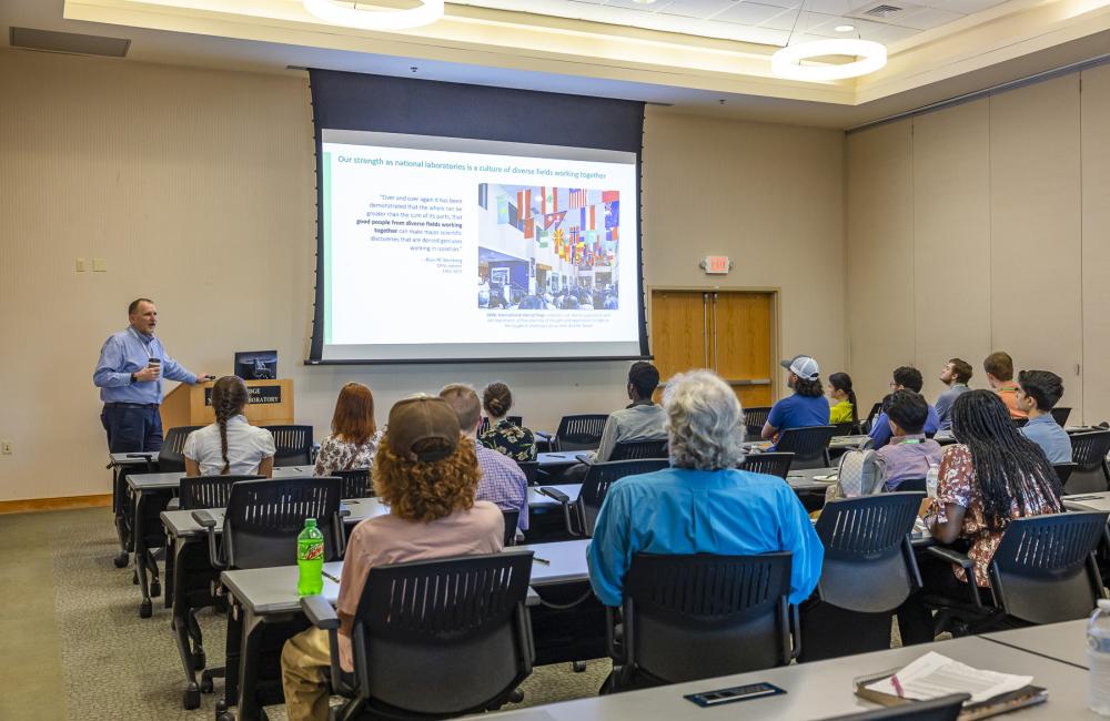 Students seated in a meeting room listening to a presenter.