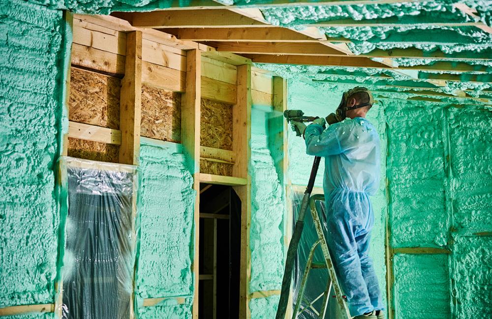 Worker spraying foam insulation