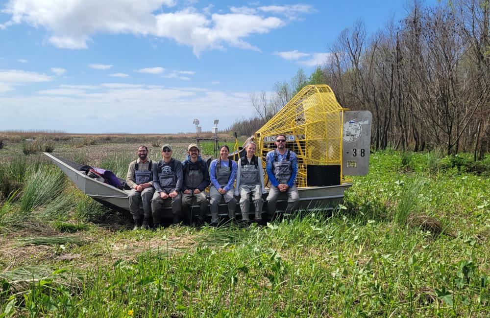 Team sits on airboat in the swamps of the Louisiana. 