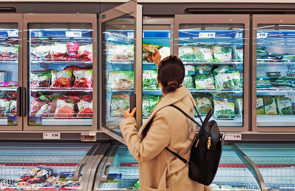 Woman shops for frozen food. Envato