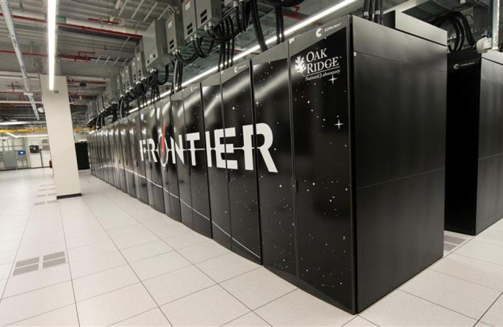 Black computing cabinets in a row on a white floor in the data center that houses the Frontier supercomputer at Oak Ridge National Laboratory