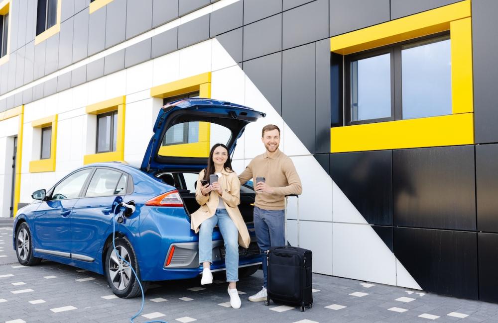 Two people standing with electric vehicle. Image from Envato