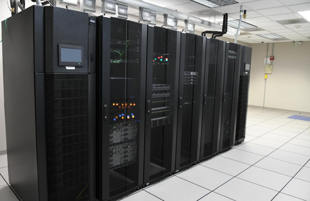 IT Department storage array server racks in a clean bright computer room at a company. Image from Envato