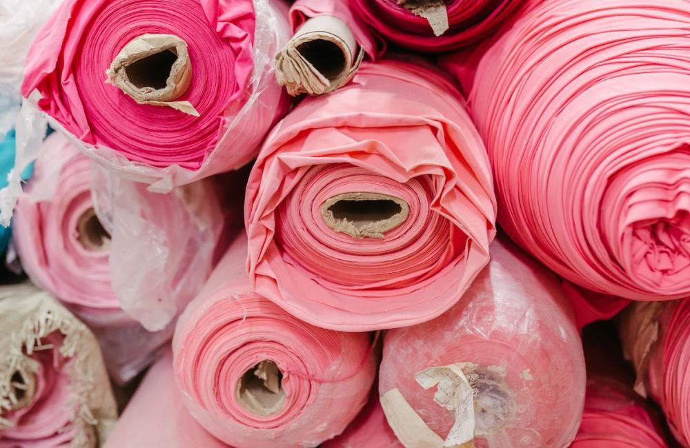 Vibrant collection of multicolored fabric rolls and swatches, arranged in a neat pile. Image from Envato