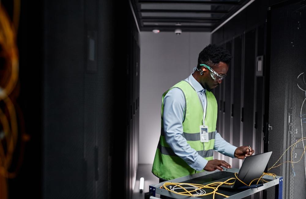 Graphic side view portrait of young network technician repairing servers in data center. Image from Envato