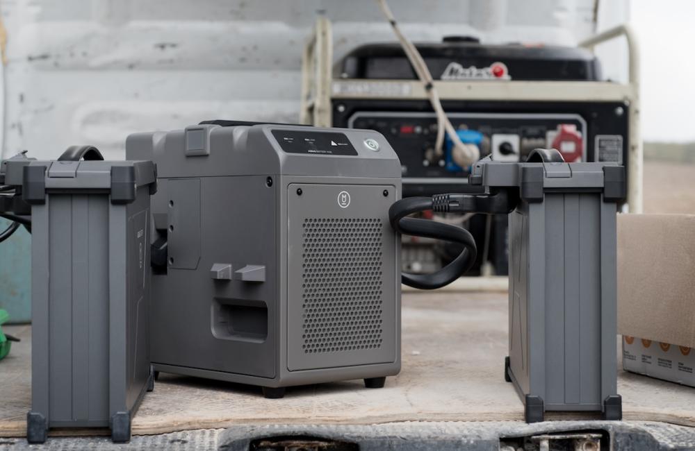 The process of charging with a charging station of two agrodrone sprayer DJI AGRAS T30 batteries from a generator in the field. Image from Envato