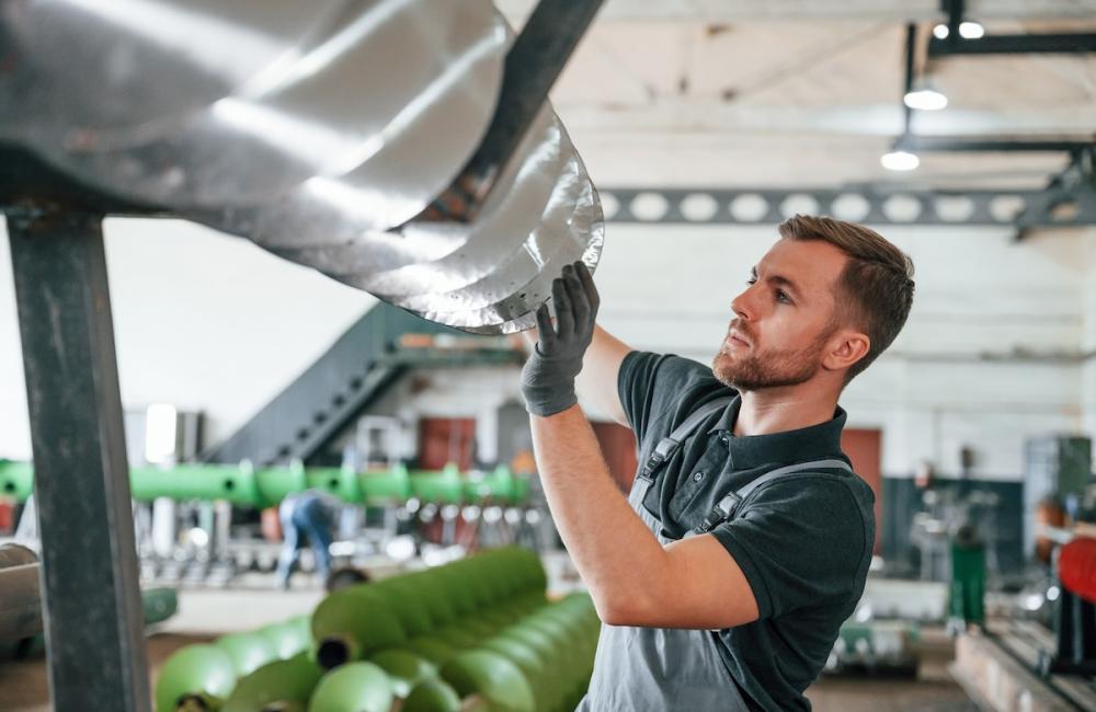 Sharp edges of equipment. Man in uniform is in workstation developing details of agriculture technique. Image from Envato