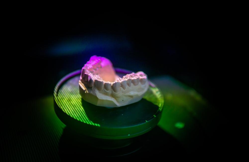 A closeup shot of a dental plaster model inside a scanner being scanned. Image from Envato