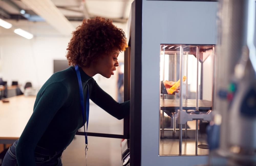 Female College Student Studying Engineering Using 3D Printing Machine. Image from Envato