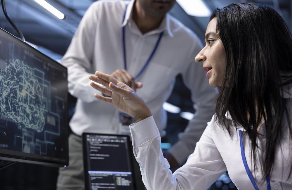 IT staff members in data center using PC to enable artificial intelligence to process datasets for training. Image from Envato