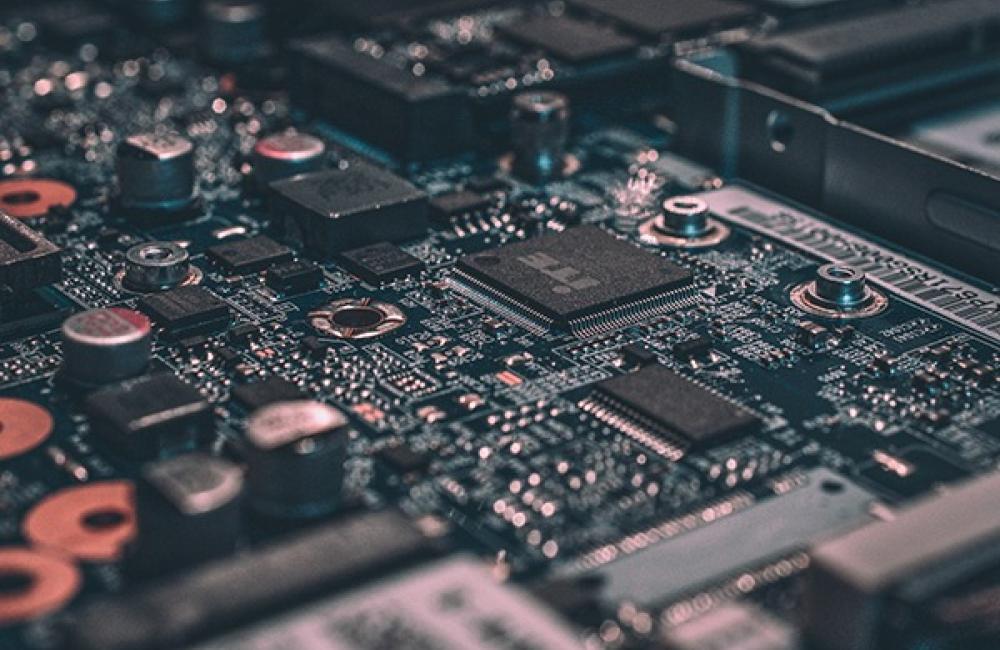 Close-up view of a detailed electronic circuit board featuring various components such as microchips and capacitors.
