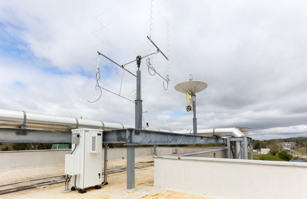 A satellite dish and antennas atop a building