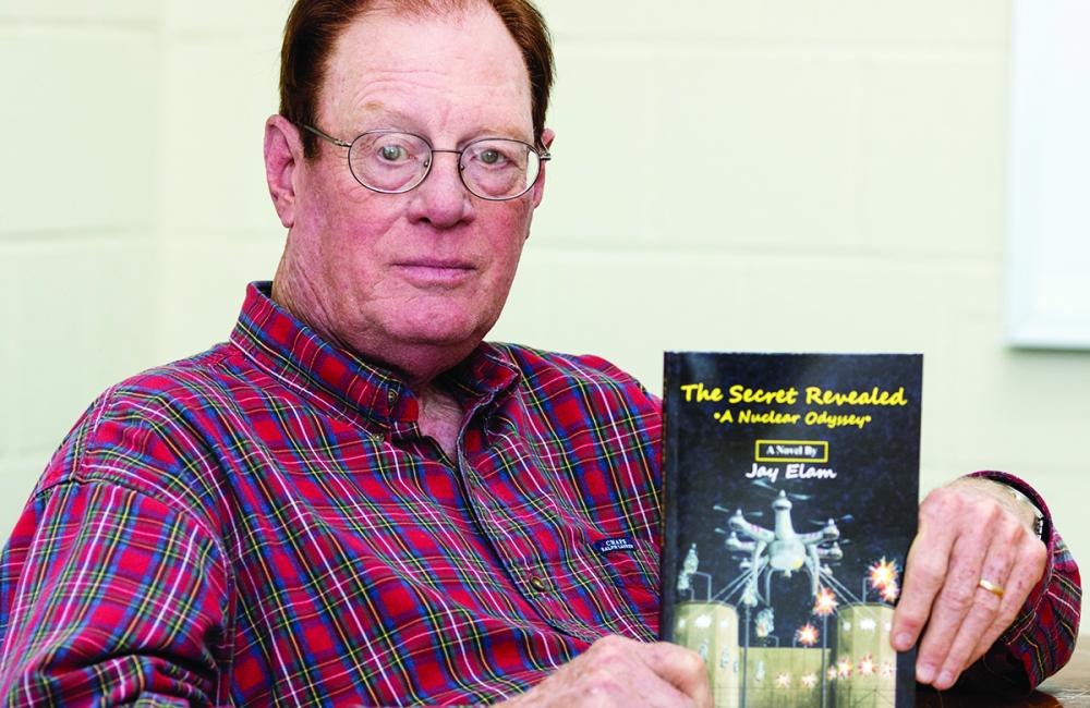 ORNL retiree Jim Ealy with his book “The Secret Revealed . . . A Nuclear Odyssey.” (ORNL Photo by Carlos Jones) 