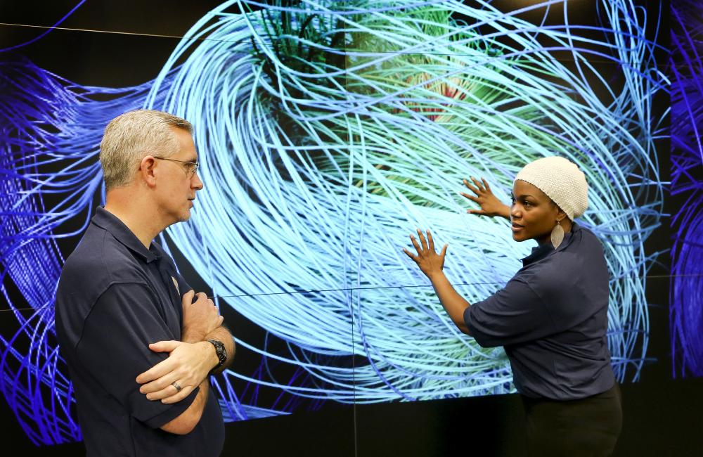 Scientists discuss a simulation in the EVEREST visualization theater of the Oak Ridge Leadership Computing Facility.