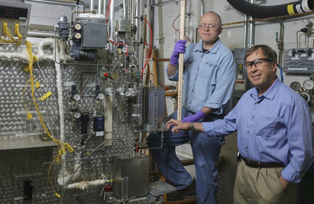 ORNL’s Jim Keiser and Mike Stephens (on stepladder) prepare to install samples in a Keiser rig, a furnace for exposing materials to corrosive gases, crushing pressures and calamitous heat. Image credit: Oak Ridge National Laboratory, U.S. Dept. of Energy;