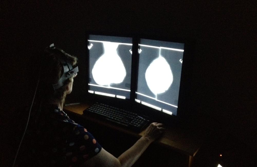 A radiologist outfitted with the team’s head-mounted eye-tracking device examines a mammogram. Credit: Hong-Jun Yoon/Oak Ridge National Laboratory, U.S. Dept. of Energy