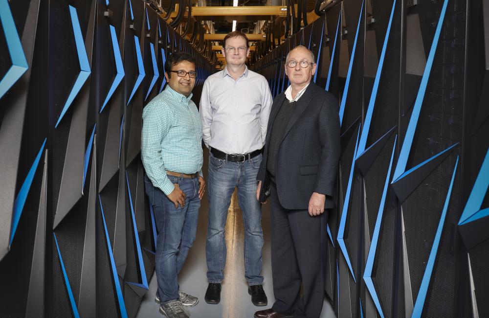 L-R: ORNL’s Arvind Ramanathan, Hugh O’Neill, and Paul Gilna inside the Summit supercomputer room. Photo courtesy: Oak Ridge National Laboratory.