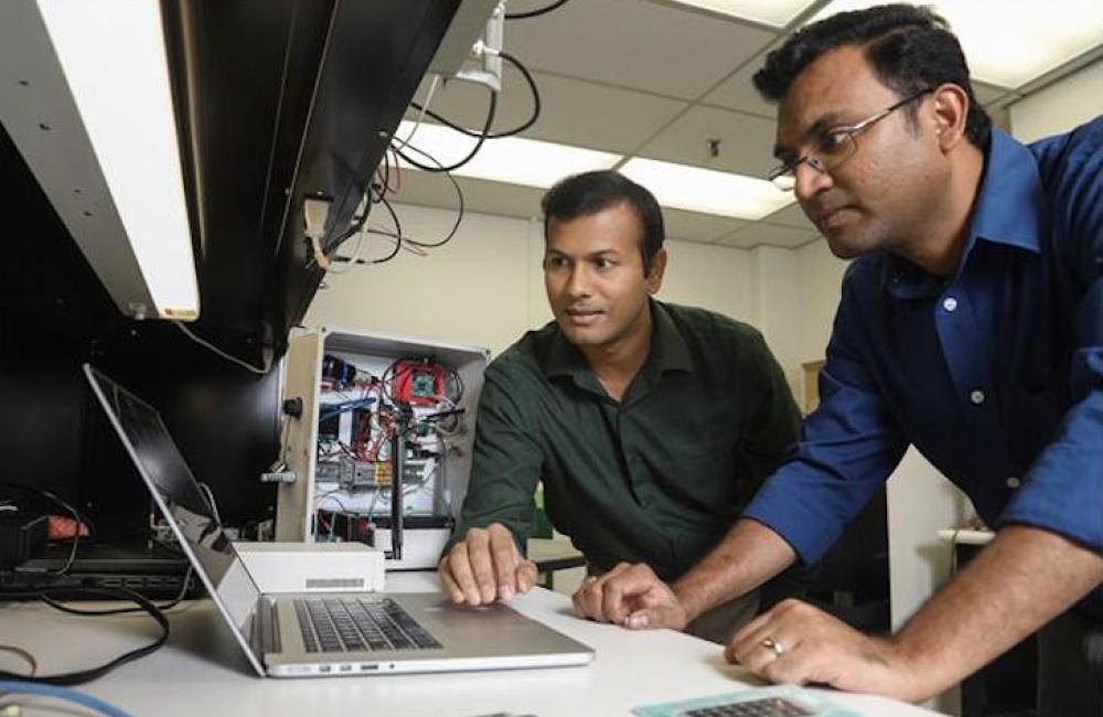 ORNL researchers Gautam Thakur (left) and Teja Kuruganti demonstrate UrbanSense, a novel sensor network aimed at helping cities manage their growth and evaluate future development opportunities. 