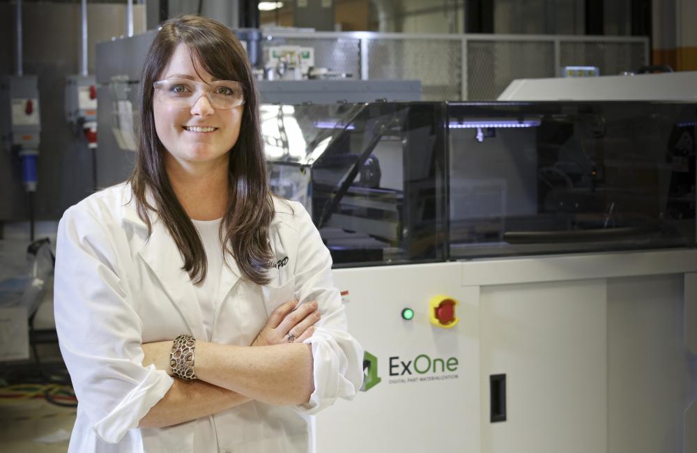 Researcher Amy Elliott and the ExOne binder jet printer at the Manufacturing Demonstration Facility.