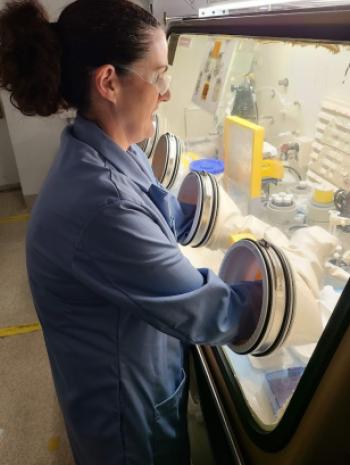 ORNL technician Summer Widner cleans a thorium-228 vial in the glove box prior to shipment. ORNL provides Th-228 for lead generators used in cancer treatment, among other applications. 