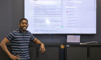 Joel Asiamah poses in front of Github and Docker code.