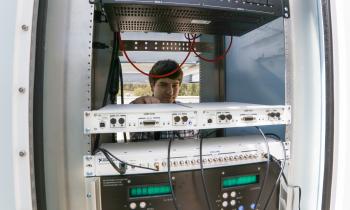 Man adjusts electronics in a rack