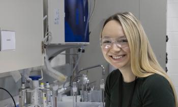 A woman in a lab smiles at the camera