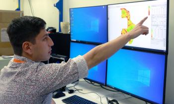 Researcher points at map on screen