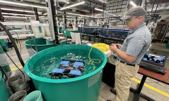 Drone operator tests an underwater drone in a large drum