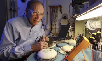researcher in a button-down shirt works with electrical measurement equipment