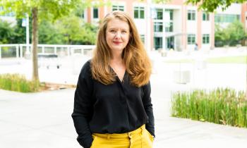 Liz Dallas stands outside at ORNL campus with trees and a building in the background