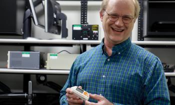 A man holds a piece of equipment used to understand how computer systems work