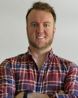 Headshot of Justin, wearing a plaid shirt