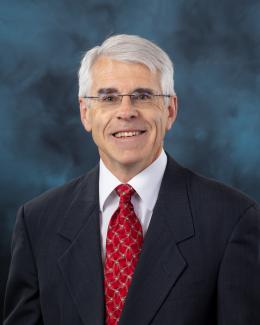 Chuck Ramsey in dark suit with red tie