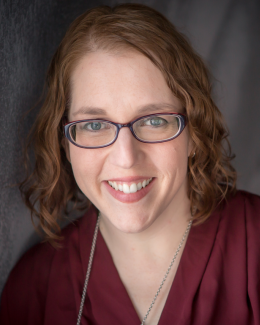 Photo of Jen Marx: smiling middle-aged white female with shoulder length wavy hair and glasses.