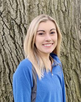 Photo of Tori smiling in front of a tree