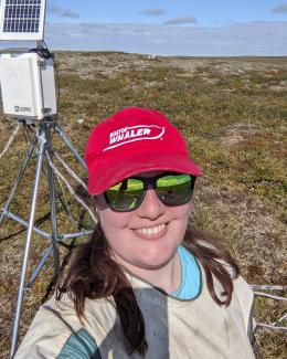 Kristen Bidas next to sensor tower on the North Slope, AK.